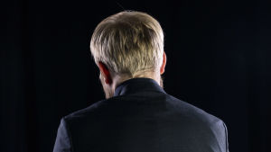 Pekka Vahvanen takaa päin kuvattuna mustassa studiossa.