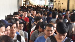 Passagerare köar för att komma ned på perrongerna i en metrostation. Under rusningstiden är metron ytterst överbelastad. Långa köer till metrostationen i Manila