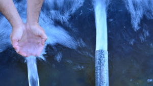 Ingå kommun behöver flera vattentag för att trygga vattenförsörjningen, säger kommundirektör Jarl Boström. Två vattenrör och en hand som tar emot vatten.