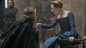 Ödesdigert möte. Lord Darnley (Jack Lowden) visar sig bära flera masker. Lord Darnley knäböjer inför sin blivande hustru Mary.