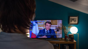En majoritet av fransmännen rapporteras ha sett presidentens tv-tal i går kväll. Fransk person tittar på Emmanuel Macrons tv-tal om coronaläget.