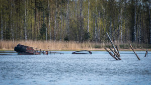 Det är inte mycket till farkost kvar av den här båten, men kanske den kan fungera som ett modernt konstverk? Sjunken båt och bryggrester skymtar i havet
