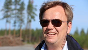 Jakob Kjellman är nöjd med hur projektet förverkligats. En man med ljusbrunt hår och solglasögon står vid en skogsöppning.