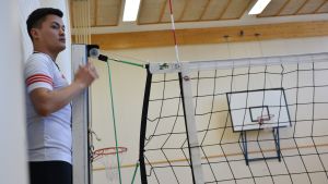 Safar Abdolrahim agerar domare i volleybollturneringen. Medan de andra lagen spelar finns både tid för umgänge och praktiska uppgifter. En kille står med koncentrerad min som volleybolldomare vid nätet