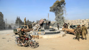Rebellerna som angrep Afrin med turkiskt stöd anklagas för en rad krigsbrott, bland annat plundring, våld mot civila och mord. Också Turkiet anklagas för urskiljningslöshet i sina bombningar. Pro-turkiska trupper firar i Afrin efter att en kurdisk staty dragits omkull.
