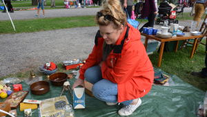 Karin Hakula med minnen från svunna tider - ett gammalt sockerpaket som hon vill sälja för fem euro. Karin Hakula sitter på huk och håller i ett gammalt Sirkku-paket med socker.