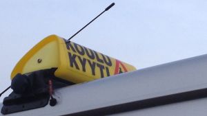 Kristian Lindroos sätter upp en skylt om skolskjutsar då han kör elever till och från skolorna. En skylt att taxin kör skoltaxi.
