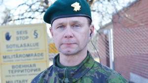 Stabschef Mika Immonen vid Nylands brigad. En bild på en man som står framför ett staket. Han är klädd i militäruniform.