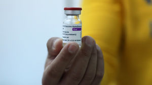 "Kommer inte på fråga att Astra Zeneca-vaccin fraktas till EU", ska USA ha sagt enligt en EU-tjänsteman nyhetsbyrån Reuters talat med. En hand som håller i en vaccinlaska.