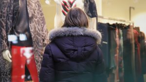 I motsats till vad man kunde tro verkar invånare i Borgå, Lovisa och Raseborg ha rört sig mer i shoppingcenter, på kaféer och liknande platser under november och december än innan coronapandemin. Månne det är julklappshandlandet som syns i statistiken? En person i vinterjacka tittar in genom ett skyltfönster till en klädbutik.