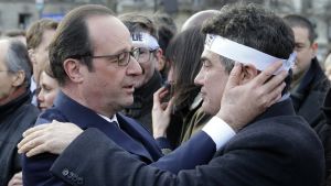 Frankrikes president Francois Hollande kramar en kolumnist vid Charlie Hebdo under manifestationen mot terrorism i Paris 11.1.2015