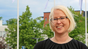 Pro Pörtös ordförande Marina Furuhjelm hoppas på fler parkeringsplatser i Kalkstrand. Arkivild. Marina Furuhjelm poserar framför flaggstänger.