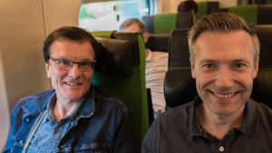 Vd Reijo Havonen från Tammerfors och tekniska chefen Christoffer Aas Clements gör affärer på tåget. två män sitter och ler i tåget