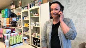 Maria Westdijk i sin butik i Närpes centrum, håller kontakt med dottern som har distansundervisning hemma
