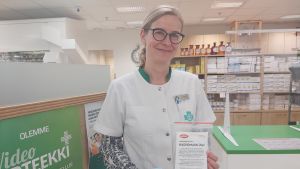 Apotekaren Anja Borgmästars har sett att kunder i större utsträckning börjat använda munskydd. Bilden är tagen före munskyddsrekommendationen trädde ikraft. Apotekare vid disk med munskydd i händerna.
