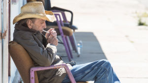 Päivän ensimmäinen savuke. Lucky iklädd cowboyhatt och boots tänder en cigg.