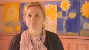 Rektor Monica Boström. Personporträtt av Monica Boström. I bakgrunden syns teckningar.