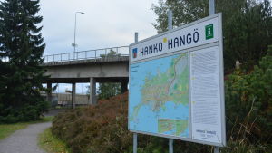 En skylt där det står Hangö och en bro i bakgrunden.