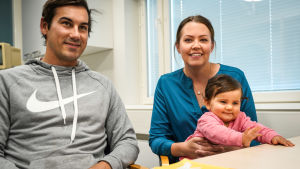 Matias Meriläinen, Jessica Bäckman och dottern Saga Bäckman. En mamma, pappa och barn vid ett bord.