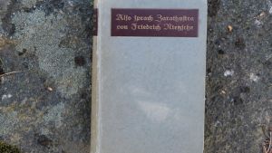 Also Sprach Zarathustra, Kriegspapier, 1918. Gammalt ex av Nietzsches Also Sprach Zarathustra, fotat mot stenbakrund. Gråa färger