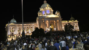 Tusentals samlades utanför parlamentet i Belgrad. Folkmassa utanför upplyst parlamentsbyggnad i Belgrad.