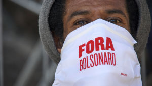 Demonstrationer mot Bolsonaros administration har ordnats på många håll i landet. Här en person med ansiktsskydd där det står "Ut med Bolsonaro". En person i ansiktsskydd i Brasilien.