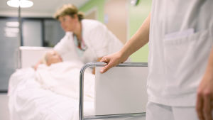 De senaste åren har det blivit svårare att få tag på vikarier inom vården. Två sjukskötare rullar en säng med en liggande patient.