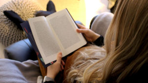 I år satsar Svenlin på kvalitet framför kvantitet i läsningen. Blond kvinna sitter i en fåtölj och tittar i en bok.