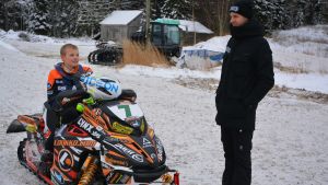 Emil och Viktor Hertén. Emil Hertén sitter på snöskotern och talar med storebror Viktor om sitt senaste träningspass.