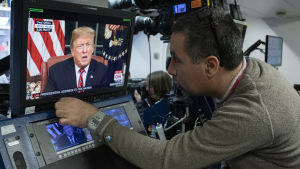 En TV-tekniker övervakar utsändningen från Vita huset. Donald Trump ses i en monitor i pressrummet i Vita huset.