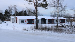 Ulrikahemmet i Kristinestad. En radhus byggnad med vita och röda väggar. Framför byggnaden finns två träd.