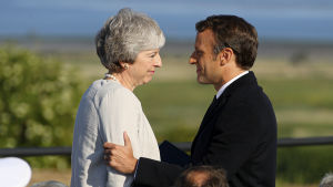 Theresa May träffar Emmanuel Macron i Normandie. macron och may hälsar på varandra