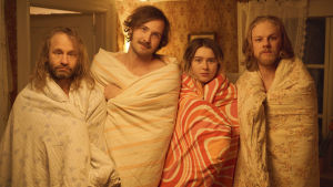 Pappa (Mattias Silvell), Gösta (Vilhelm Blomgren), Saga (Clara Christiansson Drake) och Jonas (Gustav Berg). Gösta (Vilhelm Blomgren) står med sin familj och vänner, alla har täcken om sig.