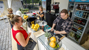 Våren var svår, berättar krögare Antti Suhonen bakom sin bardisk. En kvinna beställer en drink vid en bar på en uteservering.