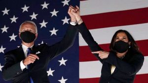 Joe Biden och Kamala Harris under segertalet. Kamala Harris står bredvid Joe Biden och håller upp hans hand.