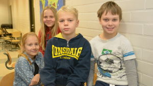 Leia Seppä (längst bak), Wilma Holmberg, Walter Forsén och Robert Siro tycker att det är bra att elever från Päivärinteen koulu finns i deras skola, Sjundeå svenska skola. Elever i Sjundeå svenska skola sitter på bord och stolar. Här syns Leia Seppä (längst bak), Wilma Holmberg, Walter Forsén och Robert Siro.