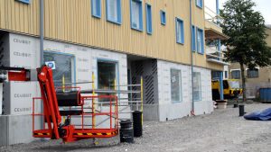 Även i bostadshusen finns det några lokaler tänkta för affärsverksamhet. En skylift framför ett bostadshus i flera våningar som ännu håller på att byggas.