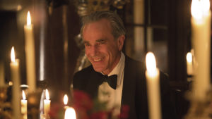 Daniel Day-Lewis i rollen som Reynolds Woodcock i Phantom Thread. Närbild på Reynolds Woodcock (Daniel Day-Lewis) vid ett middagsbord med en mängd levande ljus.