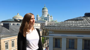 - Det är en ny och cool uppfinning men ingen vet ännu vad allt man kan använda den till, säger Janina Fagerlund från Reaktor om AI. Janina Fagerlund, som jobbar på Reaktor, står på en balkong med Helsinfors domkyrka i bakgrunden