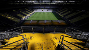 På torsdag kan det avgöras om det också i Dortmund kommer till spel inför tomma läktare. I bakgrunden en fotbollsplan sedd från en tom läktare.