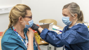 Coronavaccineringarna av hälsovårdspersonalen har kommit igång men ännu släpar man efter i tidtabellen. Sairaanhoitaja Sari Pätsi saa Keski-Suomen sairaanhoitopiirin ensimmäisen koronarokotteen.