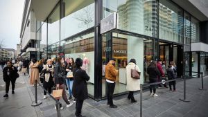 Människor köar för att gå in i en klädbutik i Rotterdam. Människor köar för att få gå in och handla kläder i Rotterdam