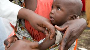 Över 200 000 barn har vaccinerats. FN-arbetare vaccinerar ett barn mot mässling i Kongo-Kinshasa