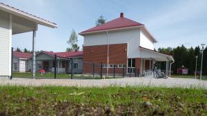 Biblioteket (till höger) är väggranne med byns nya daghem. Nya byggnader, daghem och filialbibliotek, i förgrunden nysådd gräsmatta.