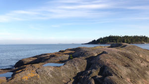 Utsikt från Rövargrundet i skärgården utanför Sommaröarna i ESbo Rövargrundets klippor med utsikt över Rövaren, havet och horisonten. Esbo skärgård utanför sommaröarna.