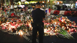 En polisman vid strandpromenaden i Nice två dygn efter attacken. En polisman står vid blomsterhavet på Promenade des Anglais i Nice den 17.7.2017.