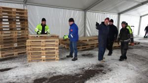 Borgå Akilles volontärer ser fram emot en stor folkfest. De frivilliga lyfter in lastpallar i VIP-tältet.