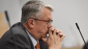 Omsorgsminister Juha Rehula lovar att vårdbolagen inte kan skumma grädden av mjölken Juha Rehula lutar huvudet mot sina händer och ser bekymrad ut.