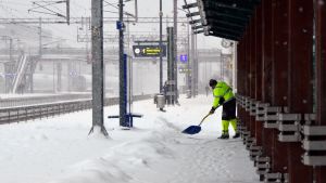 Snö skottas på perrongen på Kervo tågstation.