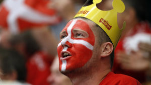 Ett danskt hockeyfan har målat sitt ansikte i danska flaggans färger. Danmark vände och vann över Schweiz.